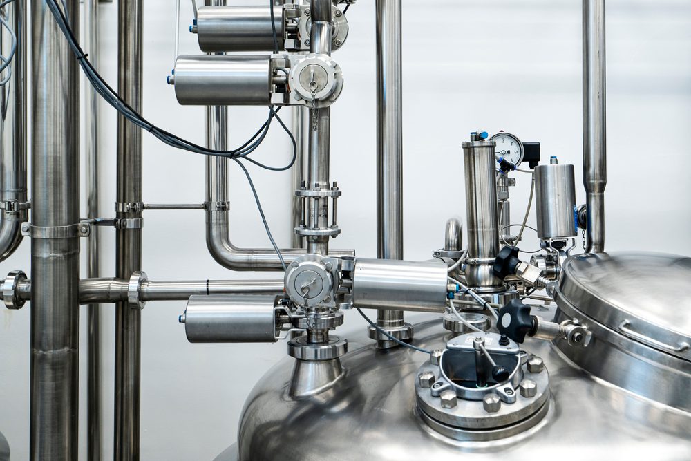 A compact stainless steel processing unit with valves and piping